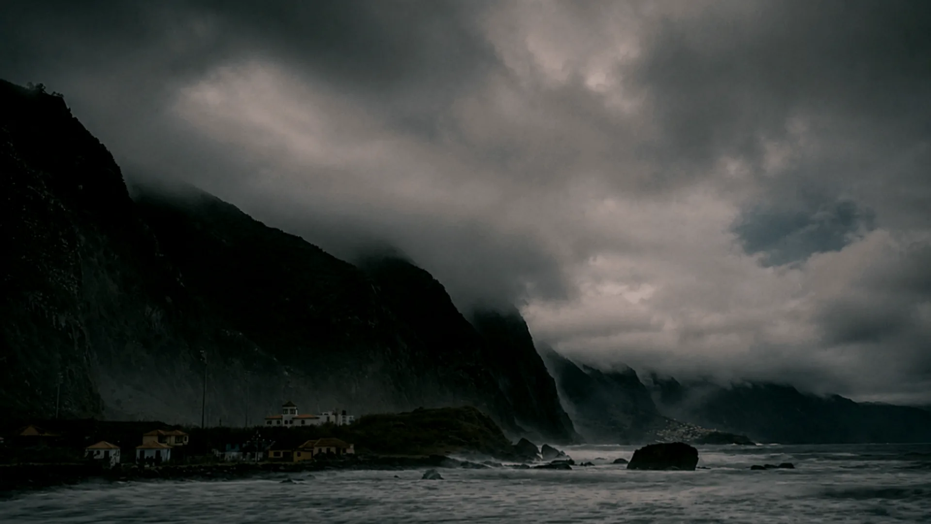 Foggy black basalt cliffs and the Atlantic Ocean on the north coast of Madeira